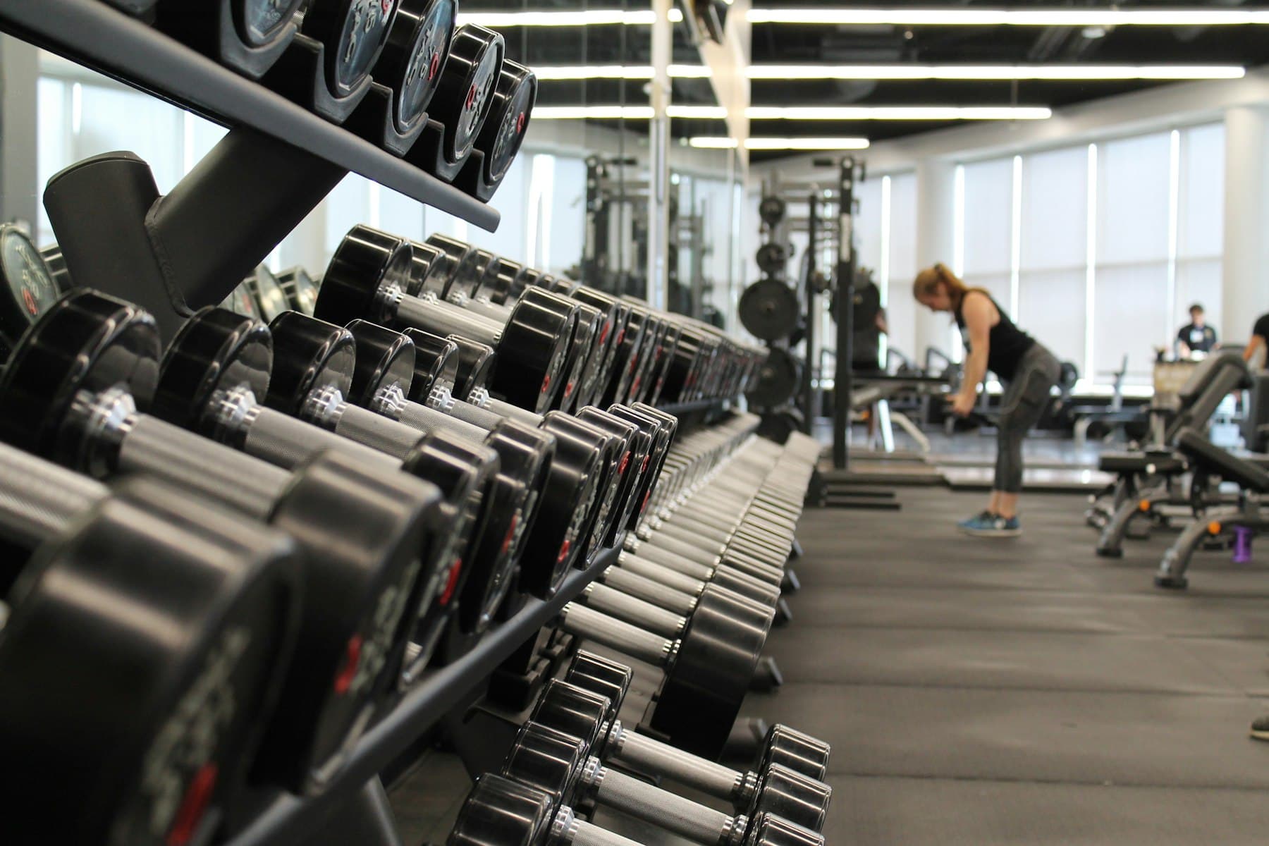 Athlete training with a barbell in a dark premium gym
