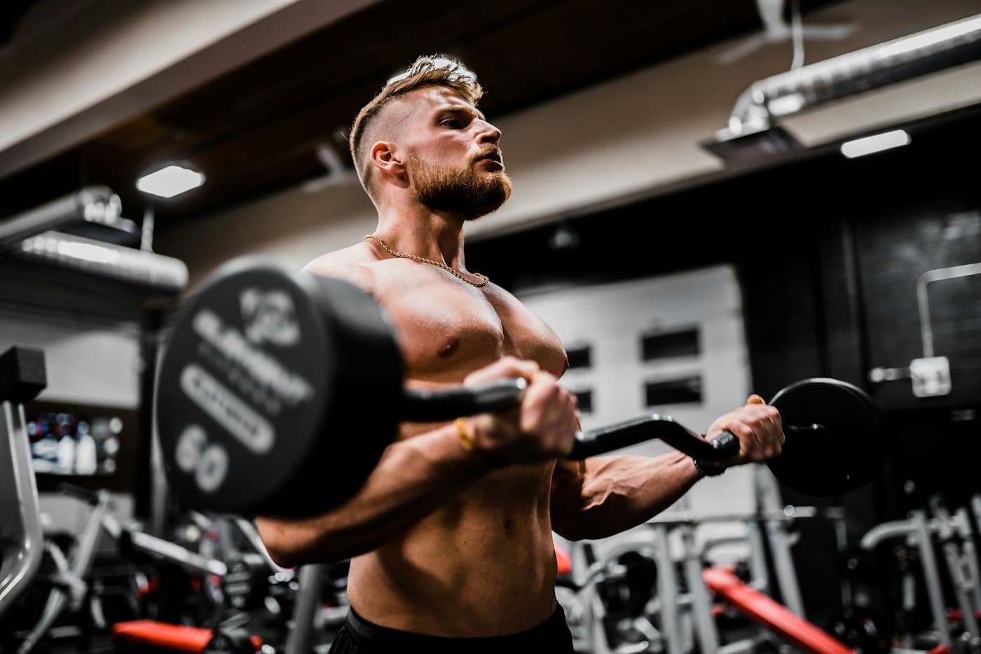 Athlete performing a barbell lift under gym lighting